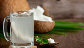 eau de coco dans un verre et noix de coco coupée en deux