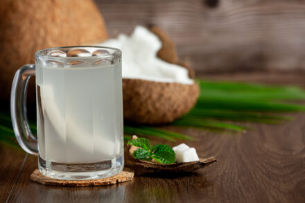 eau de coco dans un verre et noix de coco coupée en deux