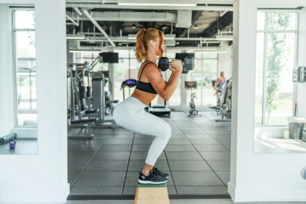 femme en salle de sport faisant des squats