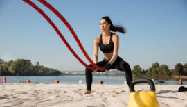 femme sportive utilisant une corde de cross-training sur la plage pour s'entraîner